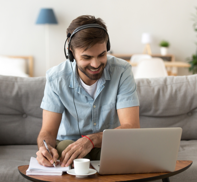 Man listening to music at desk smiling